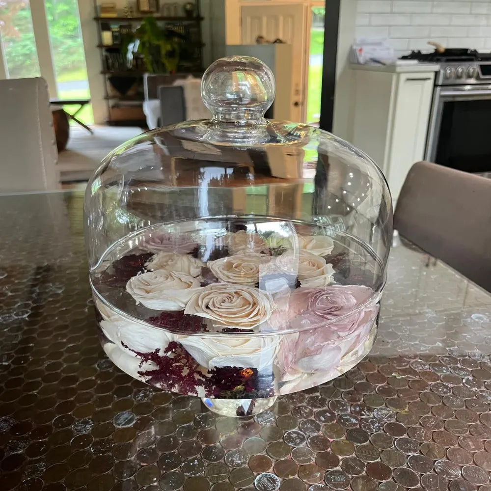 Resin Floral Preservation Cake Stand with glass dome displaying a custom preserved wedding bouquet centerpiece.