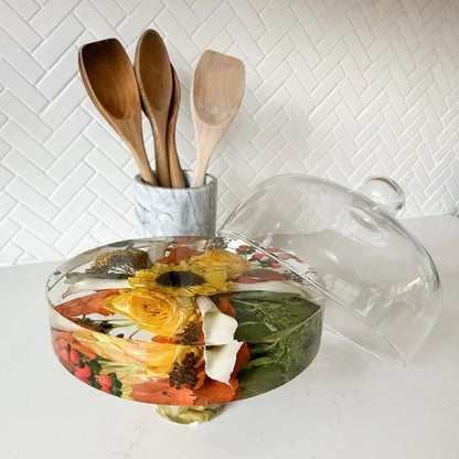 Resin Floral Preservation Cake Stand with glass dome displaying a custom preserved wedding bouquet centerpiece.