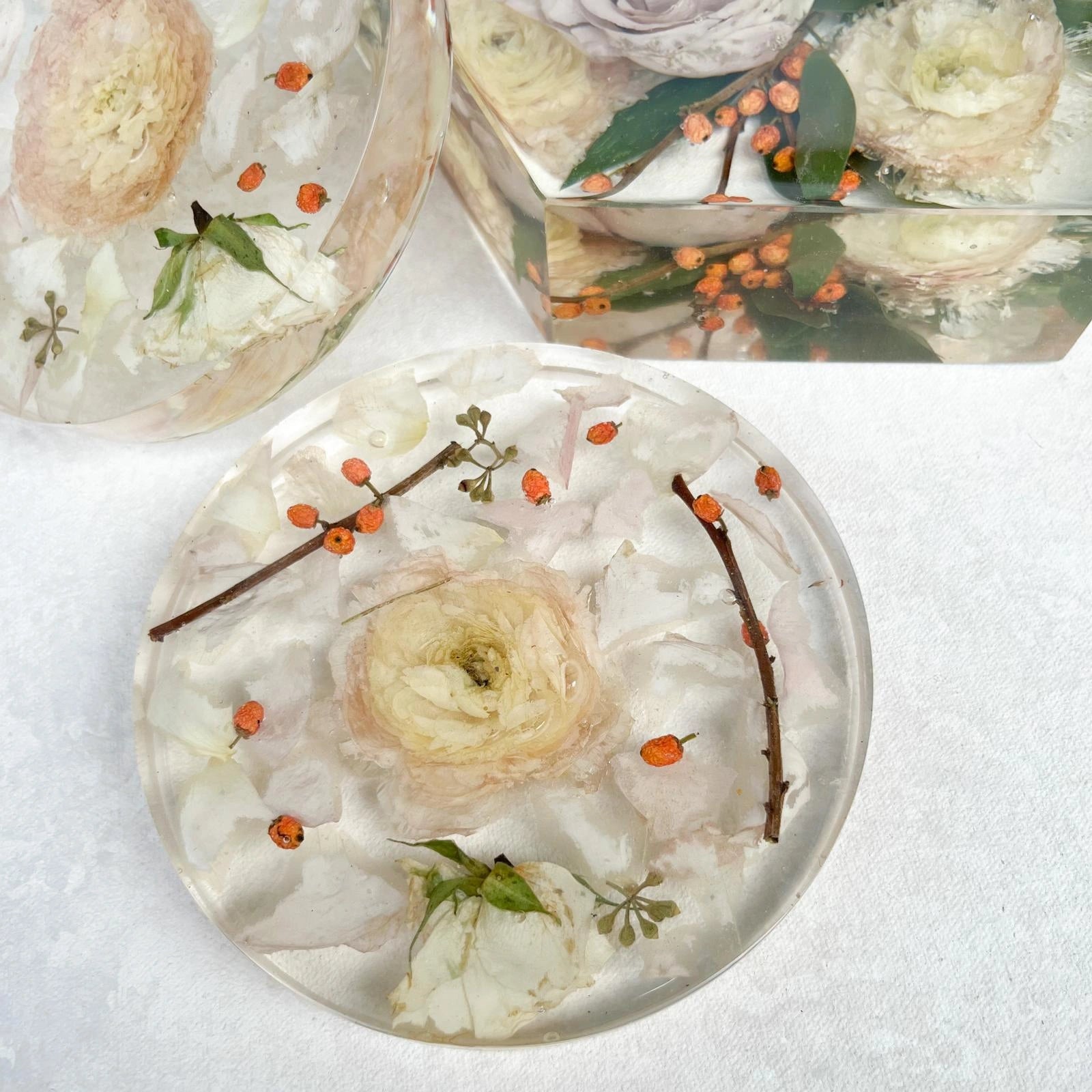 Set of Resin Floral Preservation Coasters protecting a table surface with custom wedding flowers embedded.